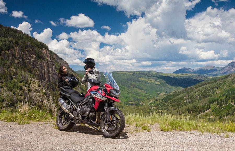 A couple taking in the mountain scenery next to their Tiger 1200 XRT