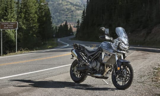 Triumph Tiger 800 Xrx parked on the side of a twisty forest road