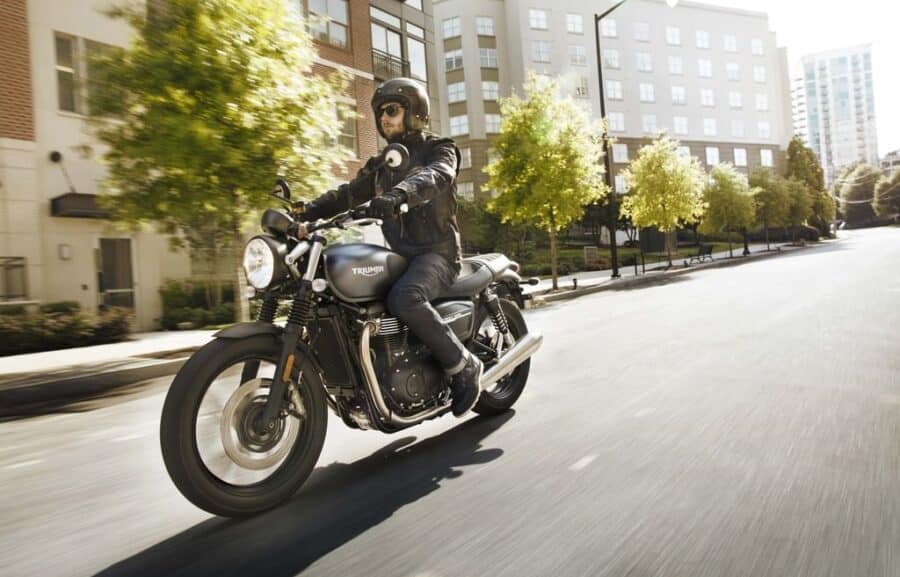 Triumph Street Twin on a city street with green tress in the background