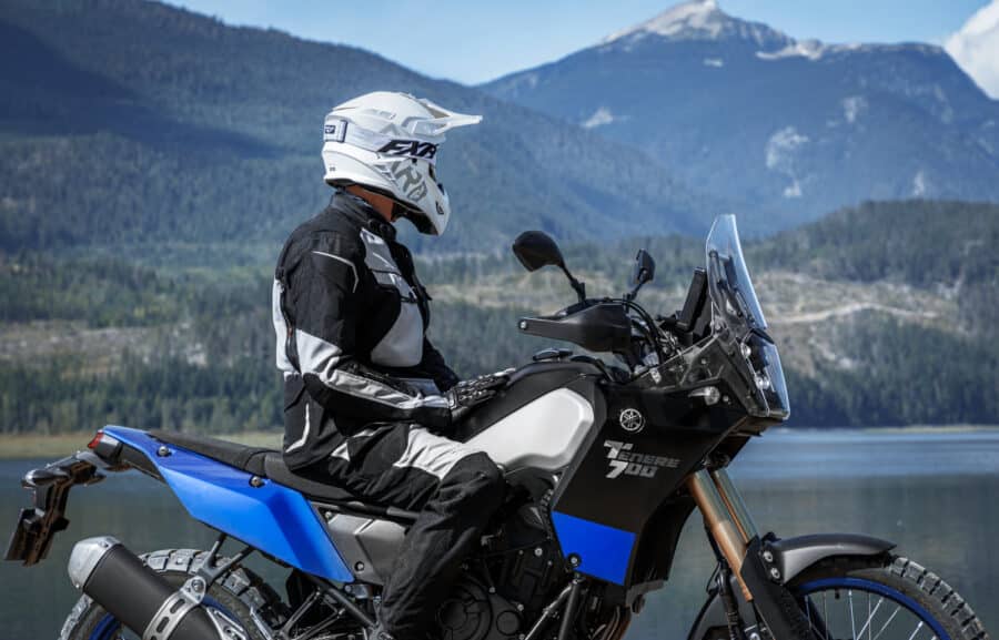Rider sitting on Yamaha Tenere 700 looking out over the ocean to the mountains.