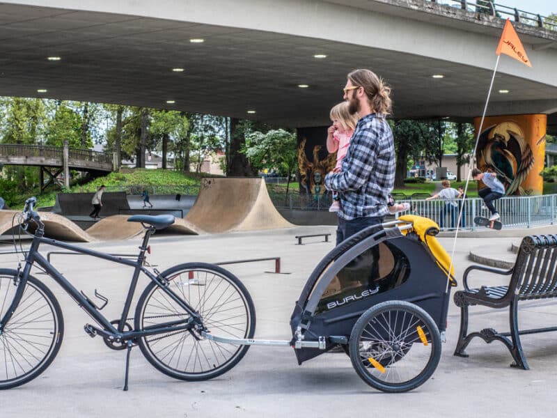 Father and child with a bicycle trailer at a skate park