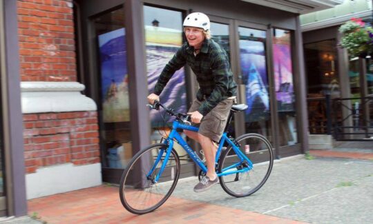 A happy man riding a blue bike