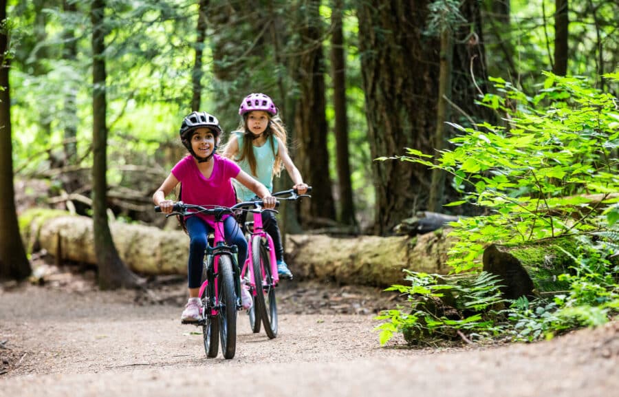 Two girls riding bikes in the forest