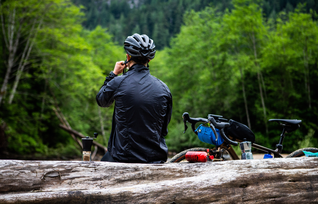 A cyclist sitting on a log taking a break