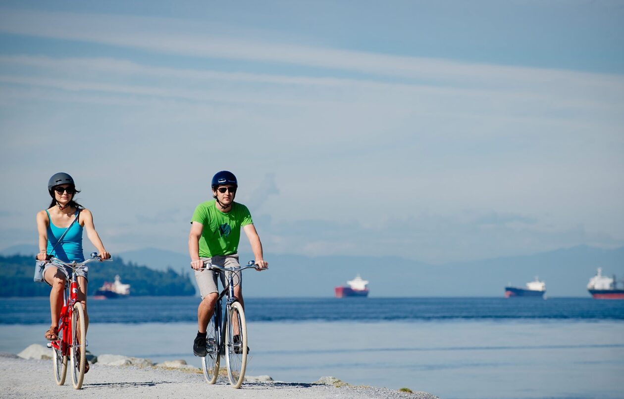 Two cyclist riding along an ocean pathway