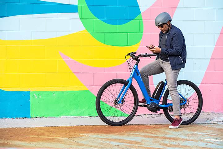A bicycle rider posing against a mural