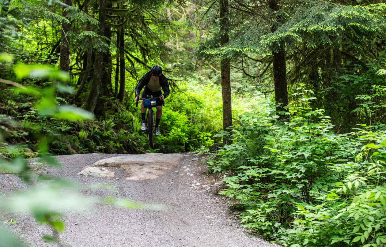 A man riding a bike through the forest