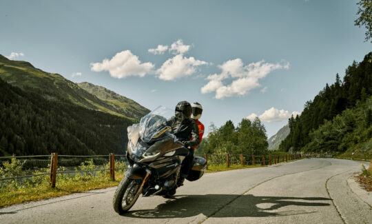 A couple riding a BMW R 1250 RT TFT on a mountain road