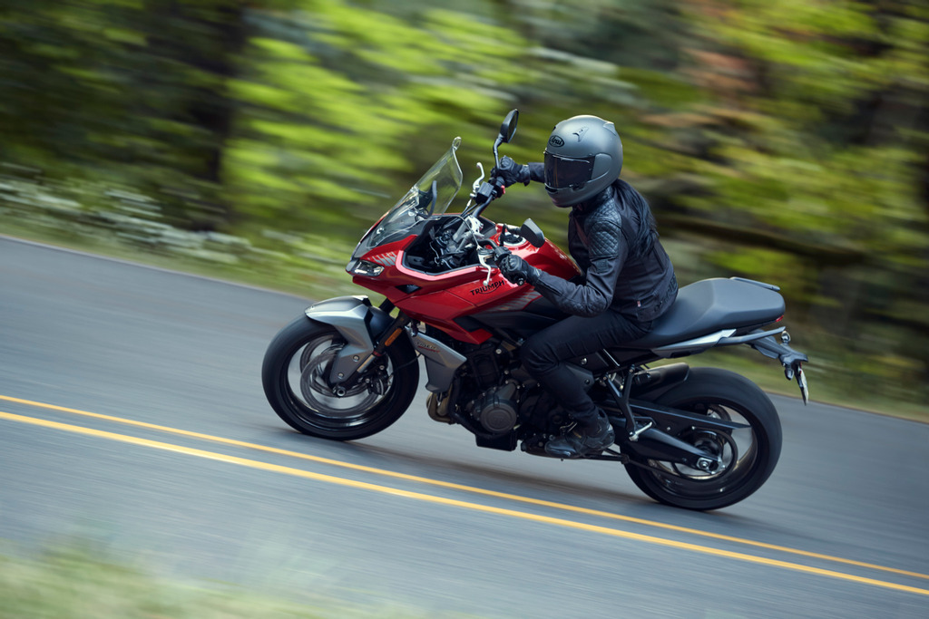 Triumph Tiger Sport 660 in a hard lean with the forest background blurred