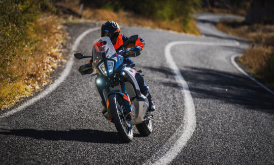 A KTM 790 ADV rider on a twisty road