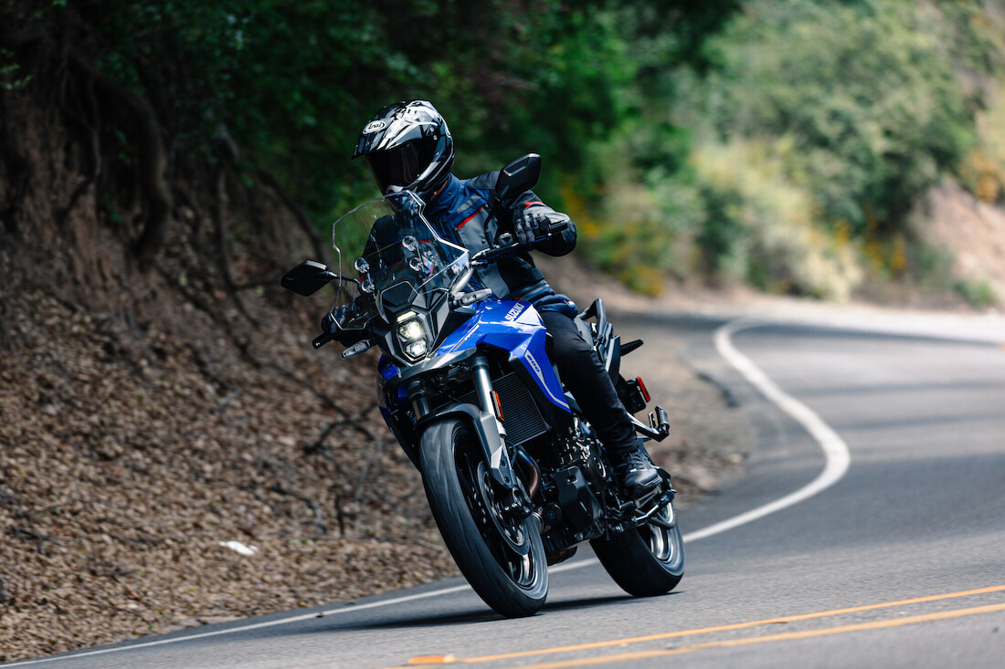 An Adventure rider on a twisty road riding a blue Suzuki V-Storm 800