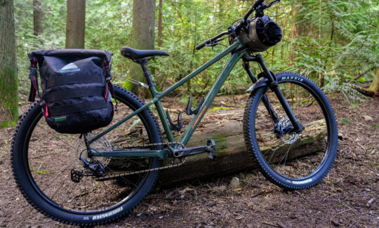 Mountain bike with panniers on forest trail