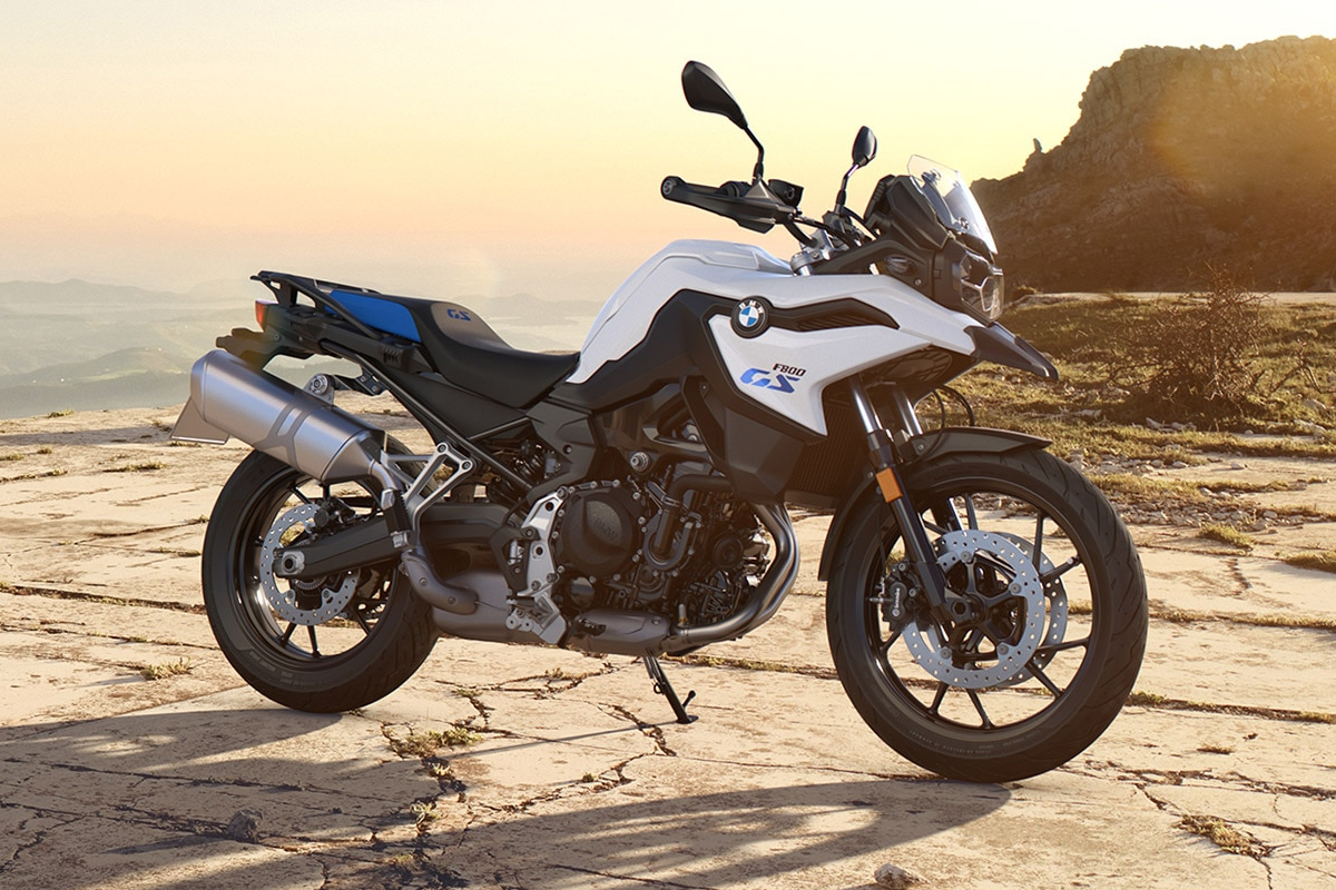 BMW motorcycle parked on sunny rocky terrain.