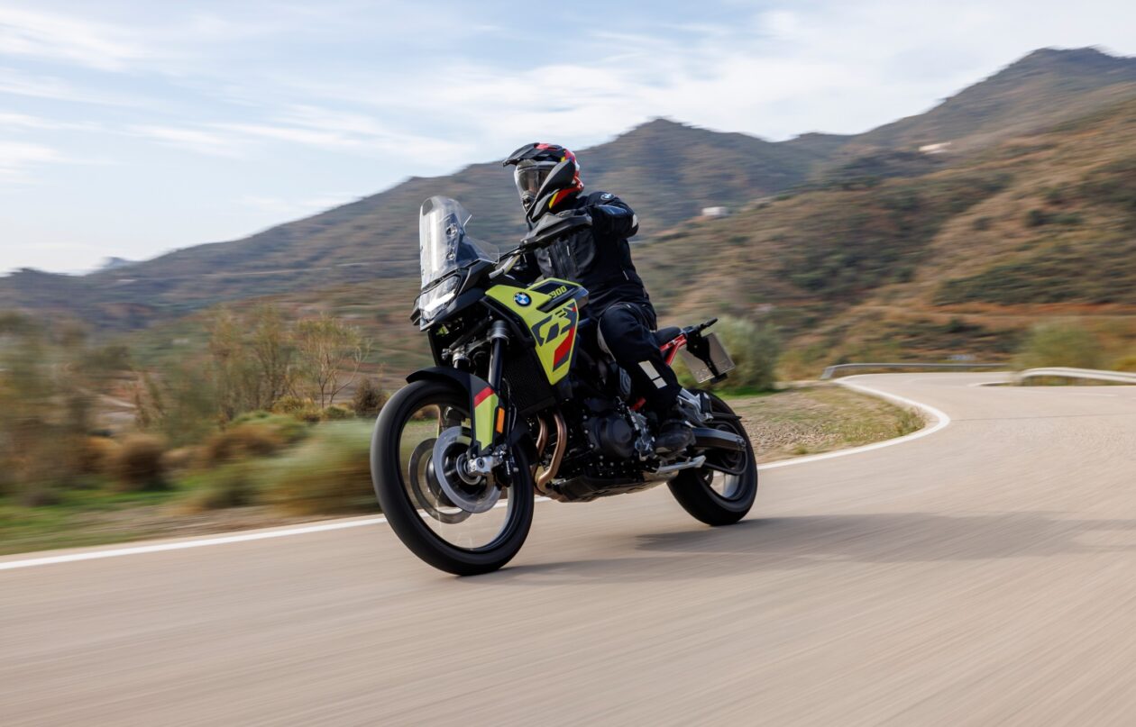 Motorcyclist riding on a scenic mountain road.