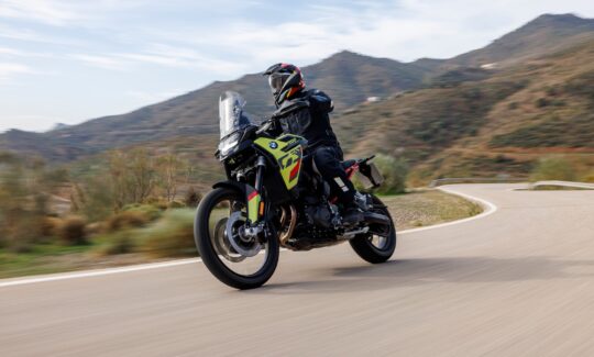 Motorcyclist riding on a scenic mountain road.
