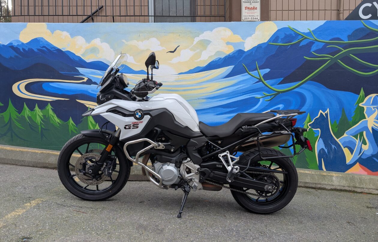 Motorcycle parked by colourful mural