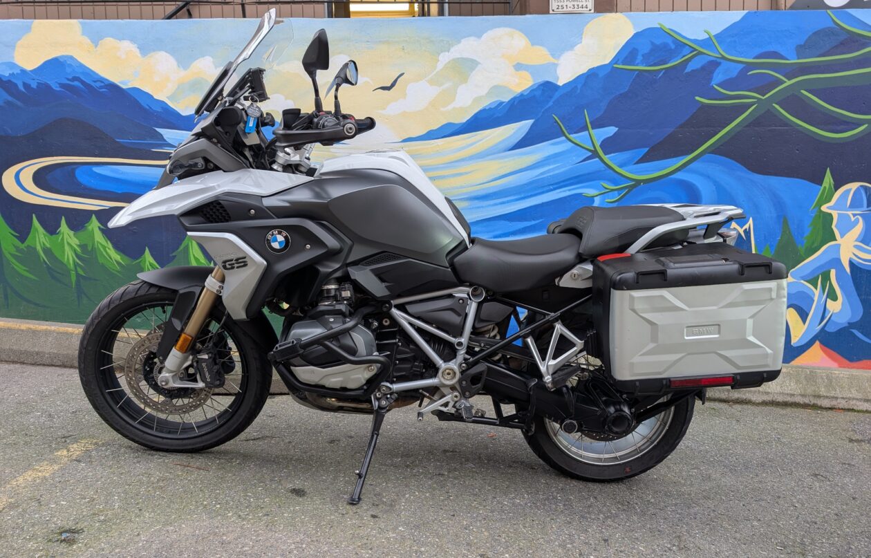 Motorcycle parked beside mountain mural.
