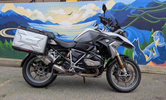 Motorbike parked in front of colorful mural.