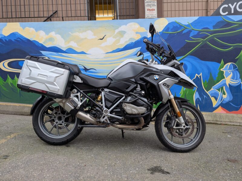 Motorbike parked in front of colorful mural.