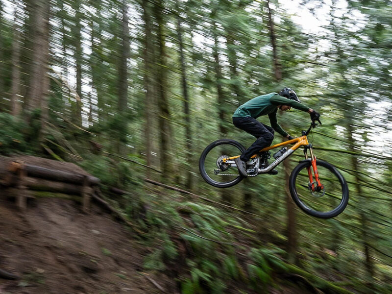 Mountain biker airborne on forest trail